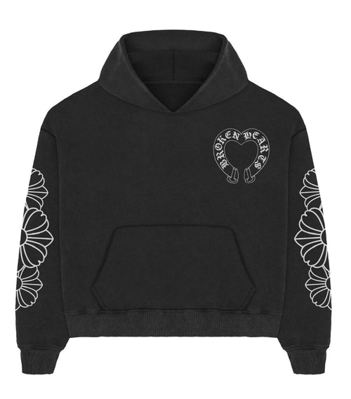 Front of a black Broken Hearts boxy hoodie with chest horseshoe heart logo, daisy floral sleeves and kangaroo pocket